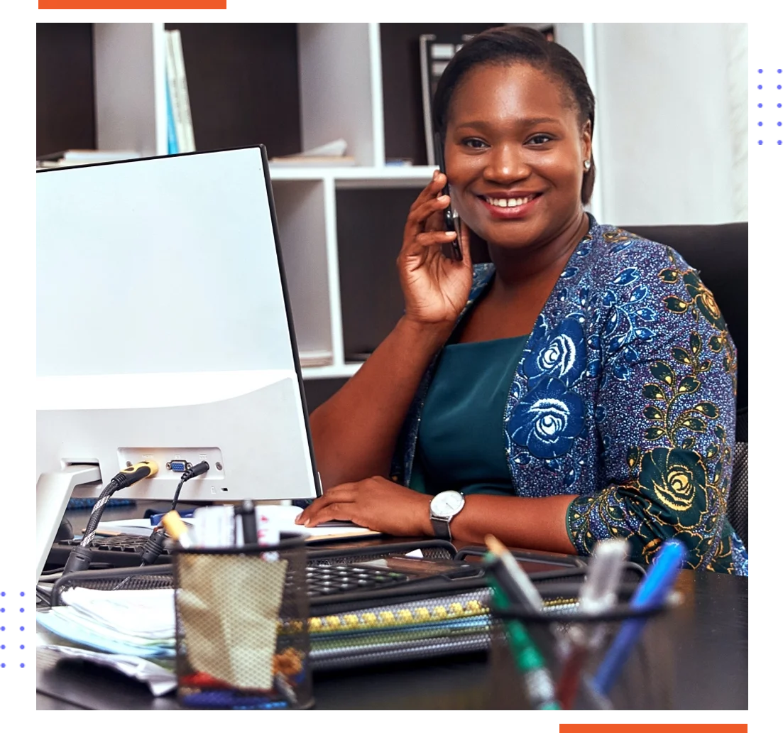 A woman sitting at her desk on the phone