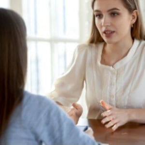 Two women engaged in a focused conversation.