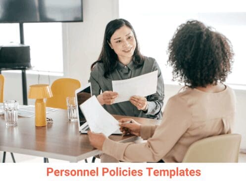 Two women discussing personnel policies in office.